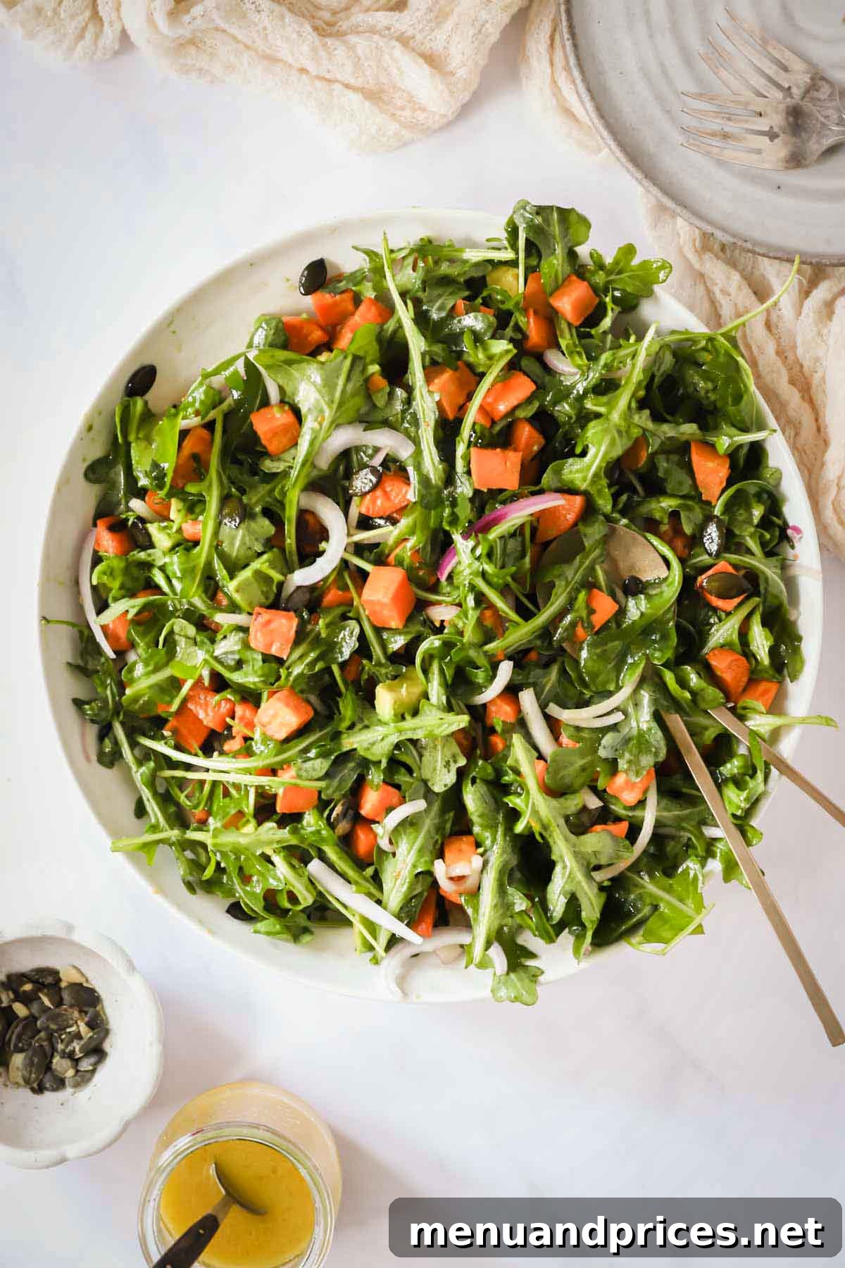 Creamy Sweet Potato Delight 2 Overhead image of a vibrant sweet potato salad with roasted sweet potatoes, arugula, and other fresh ingredients in a large white bowl.