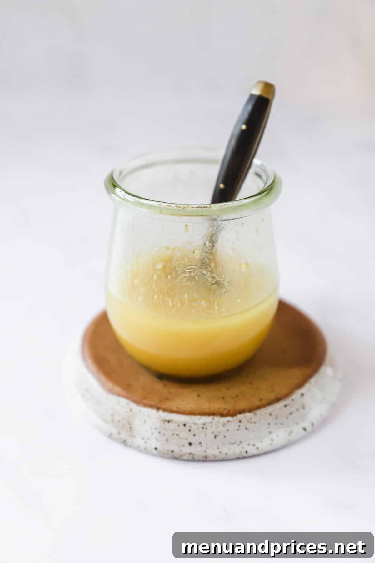 Creamy Sweet Potato Delight 6 A glass jar containing a freshly mixed honey mustard vinaigrette dressing, with a spoon gently resting inside.
