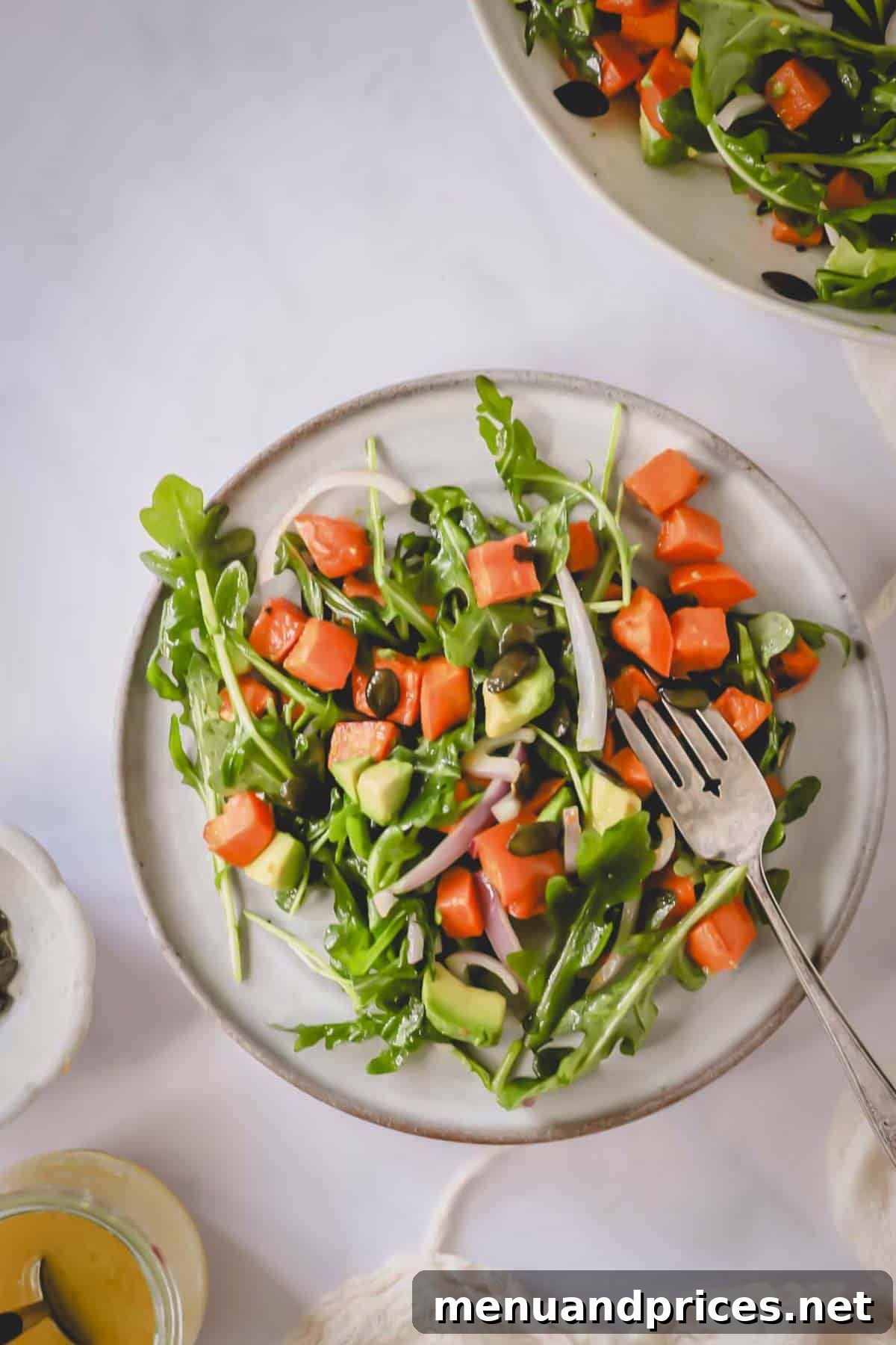 Creamy Sweet Potato Delight 9 Overhead image of a single, perfectly portioned serving of sweet potato salad presented on a white plate with a fork.