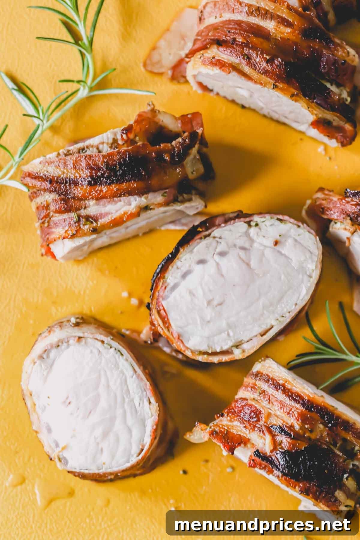 The Ultimate Bacon-Wrapped Pork Tenderloin 9 Sliced pieces of baked bacon wrapped pork tenderloin arranged on a serving board.
