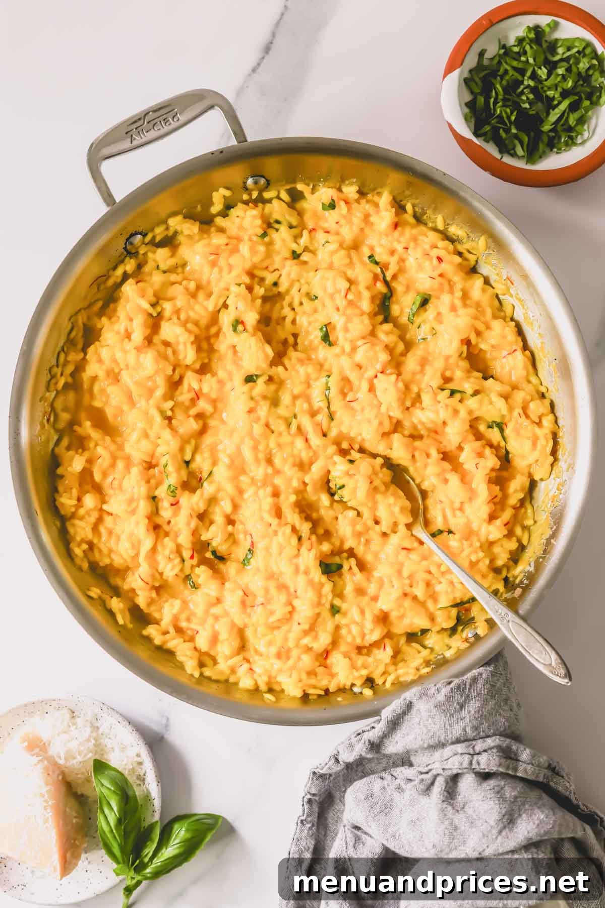 Express Golden Saffron Risotto 8 A pan of saffron risotto topped with fresh herbs, with a serving spoon waiting to dish it out.