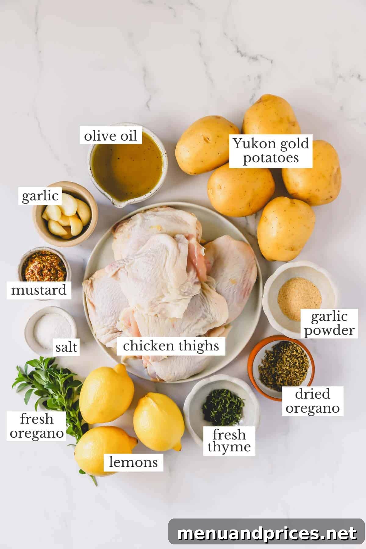 A vibrant flat lay of all the fresh ingredients needed to make Greek lemon chicken and potatoes, including lemons, chicken, potatoes, and herbs.