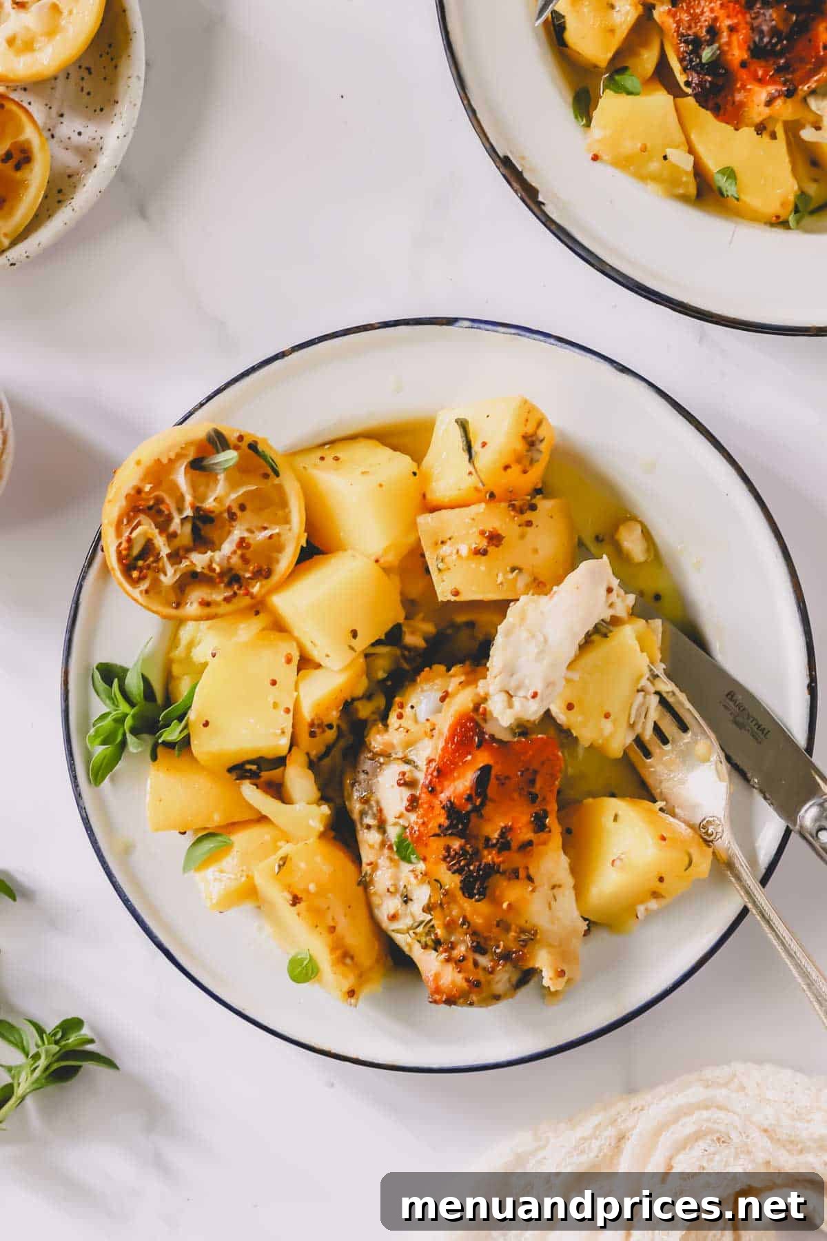 A close-up shot of a plate of Greek lemon chicken and potatoes, with a fork holding a delicious bite of chicken and potato, highlighting the tender texture.