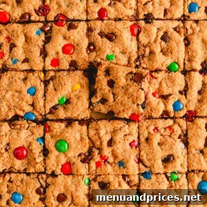 Sliced monster cookie bars with one square sticking up, enticingly presented.