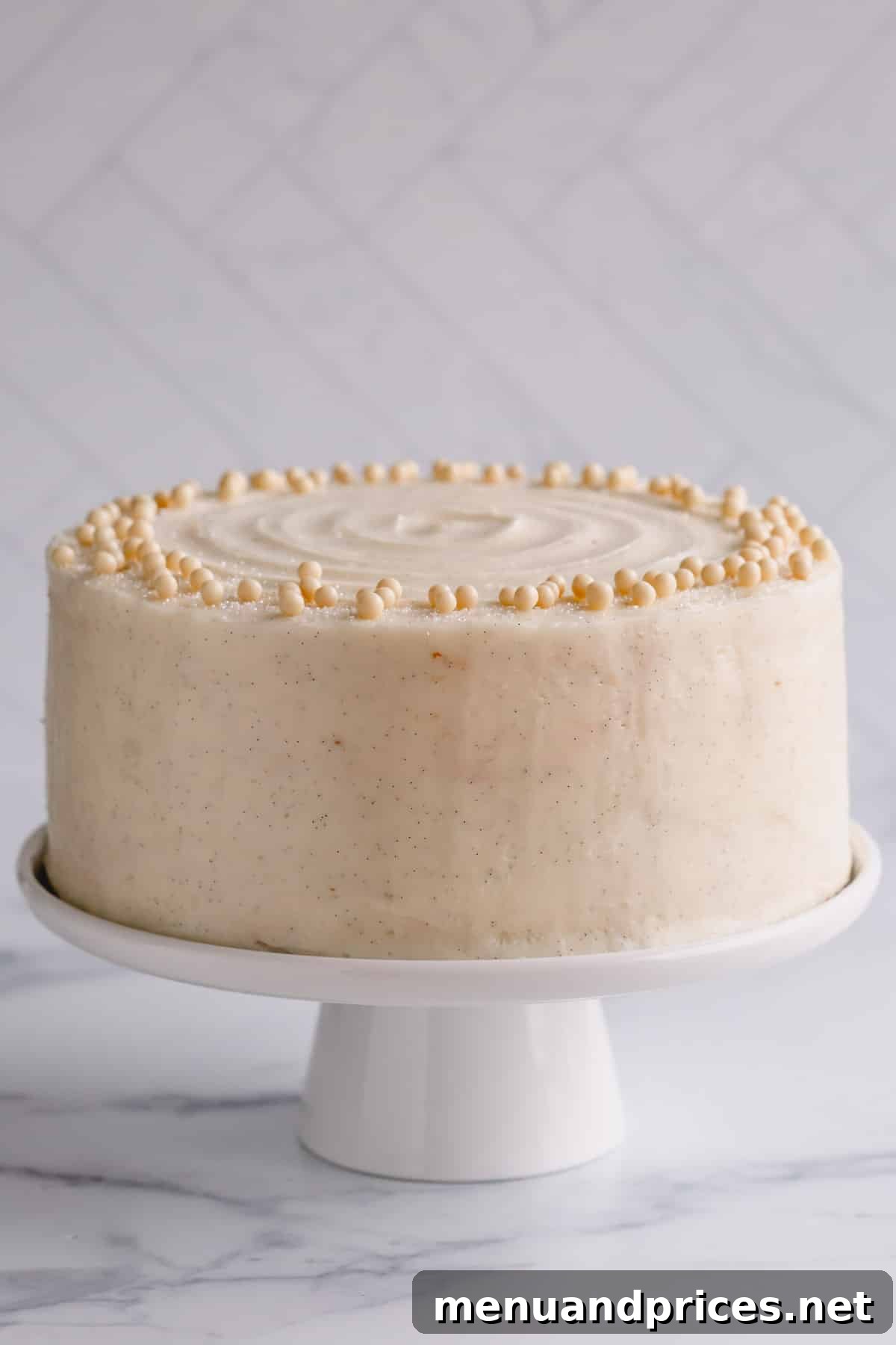 Fluffy White Cake Perfection 2 A beautifully frosted classic white cake on an elegant cake stand, adorned with silky vanilla buttercream.