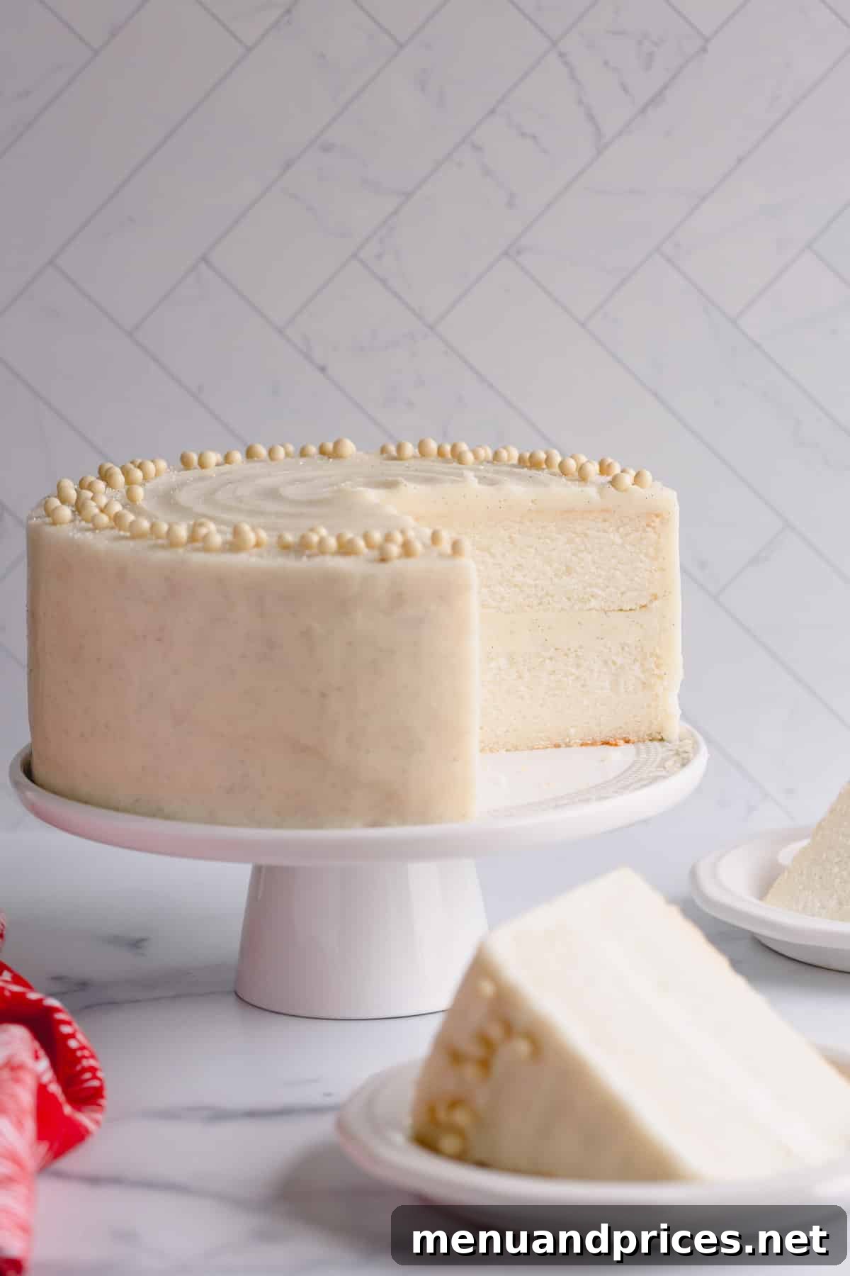 Fluffy White Cake Perfection 13 A perfectly frosted classic white cake, with a clean slice revealing its tender layers, poised for enjoyment.