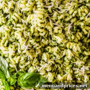 Basil pesto pasta topped with parmesan and fresh basil.
