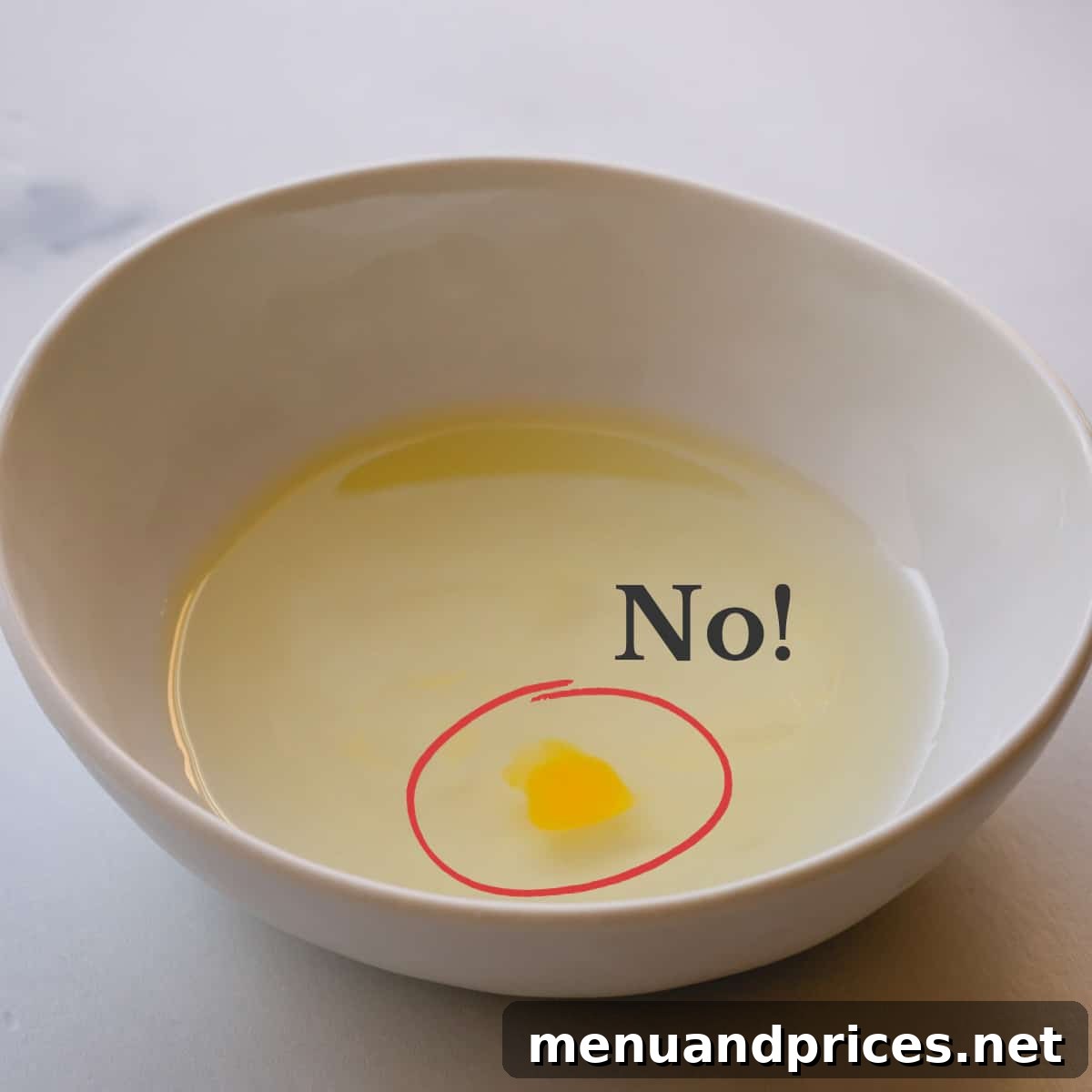 The Secret to Perfect Egg White Separation 4 A bowl of egg whites with a small, visible drop of egg yolk and a bold red text overlay that says "NO!" indicating contamination.