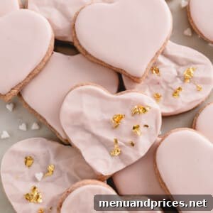 Raspberry sugar cookies decorated with pink icing and gold leaf.