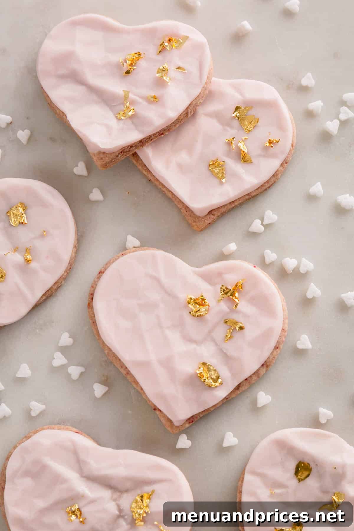 Raspberry Dream Cookies 3 Raspberry heart-shaped sugar cookies with pink icing and gold leaf decoration, close-up.
