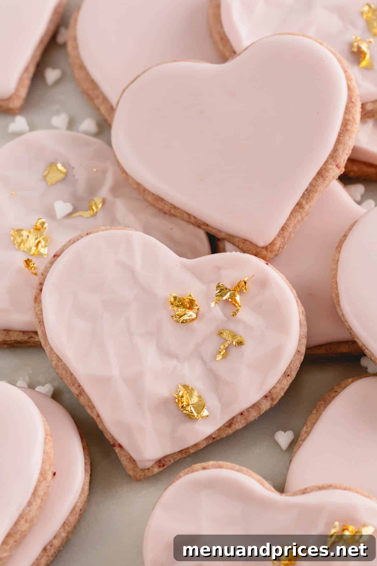 Raspberry Dream Cookies 10 Heart-shaped raspberry sugar cookies with a mix of smooth and textured icing, adorned with gold leaf decorations.