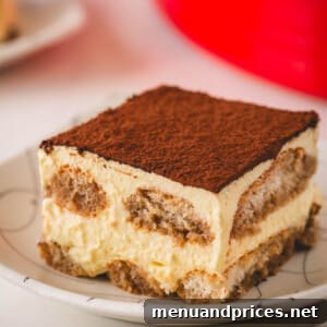Authentic Italian Tiramisu 16 A square of classic tiramisu on a plate.
