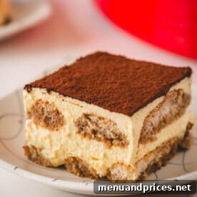 Authentic Italian Tiramisu 17 A square of classic tiramisu on a plate.