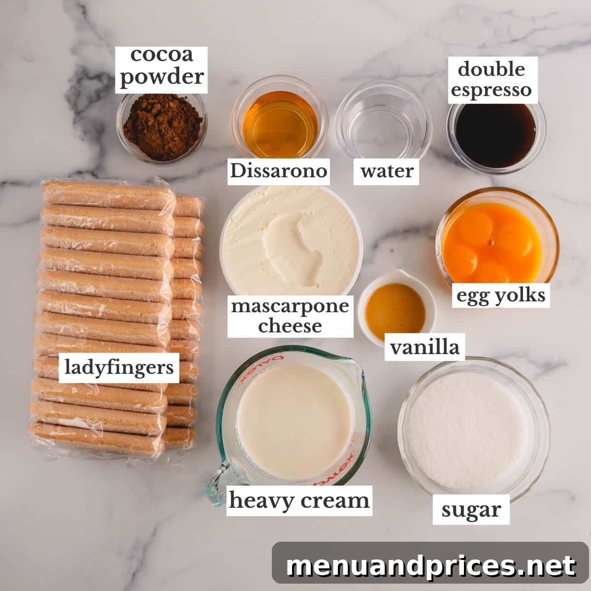 Authentic Italian Tiramisu 4 A collection of key ingredients artfully arranged on a kitchen surface, showcasing the components needed to create a delicious classic tiramisu. Ingredients include ladyfingers, mascarpone cheese, espresso, Amaretto, eggs, and cocoa powder.
