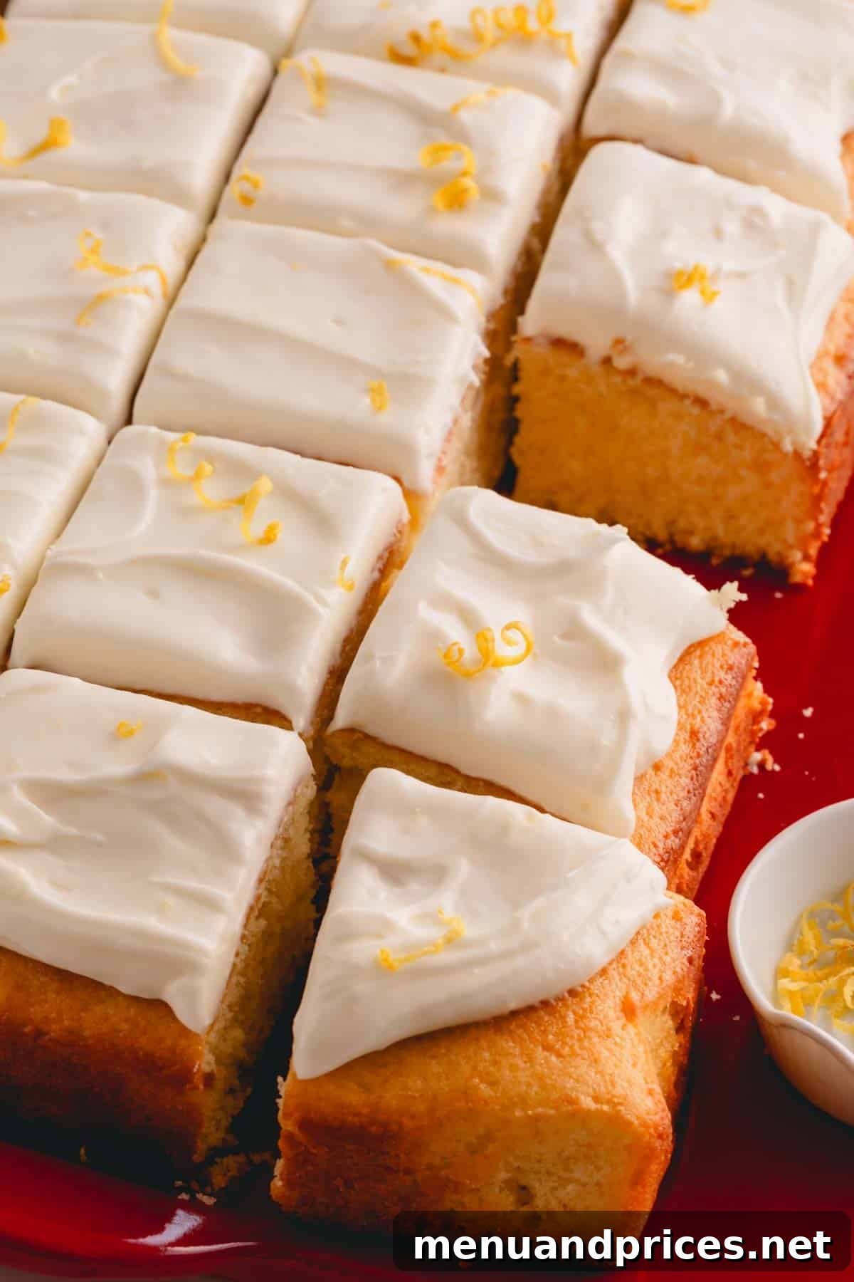 Perfectly frosted squares of yellow cake, showcasing the smooth and inviting lemon cream cheese frosting.