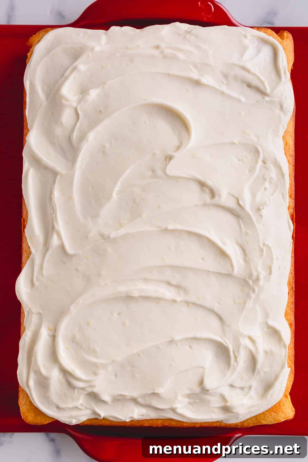 A beautifully frosted yellow cake, perfectly showcasing the light and airy texture of the lemon cream cheese frosting.