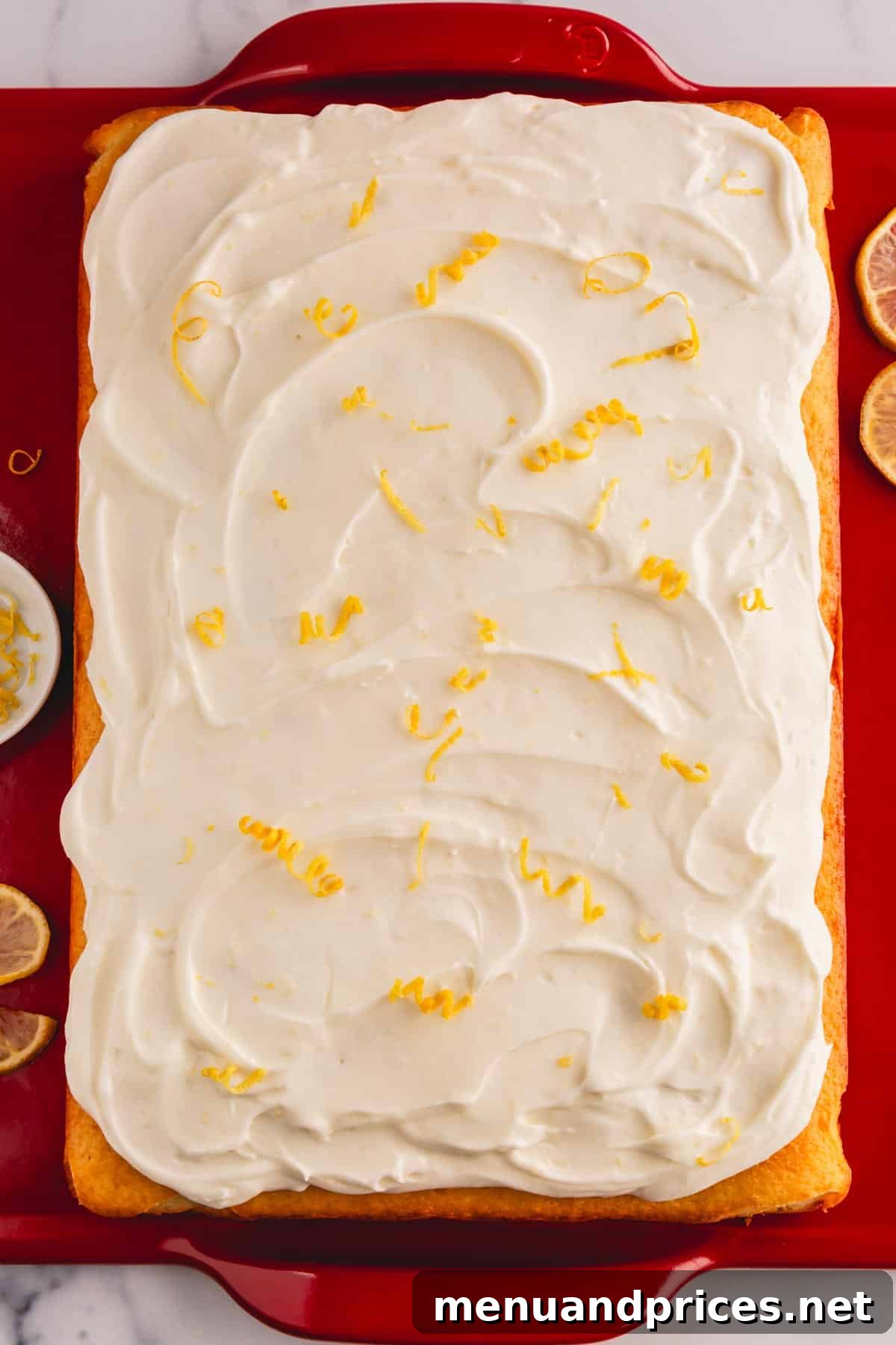 Sunshine Lemon Sheet Cake 12 A stunning lemon cream cheese cake, exquisitely topped with a generous layer of luscious lemon cream cheese frosting, artfully garnished with fresh lemon zest for an added touch of vibrant color and aroma.