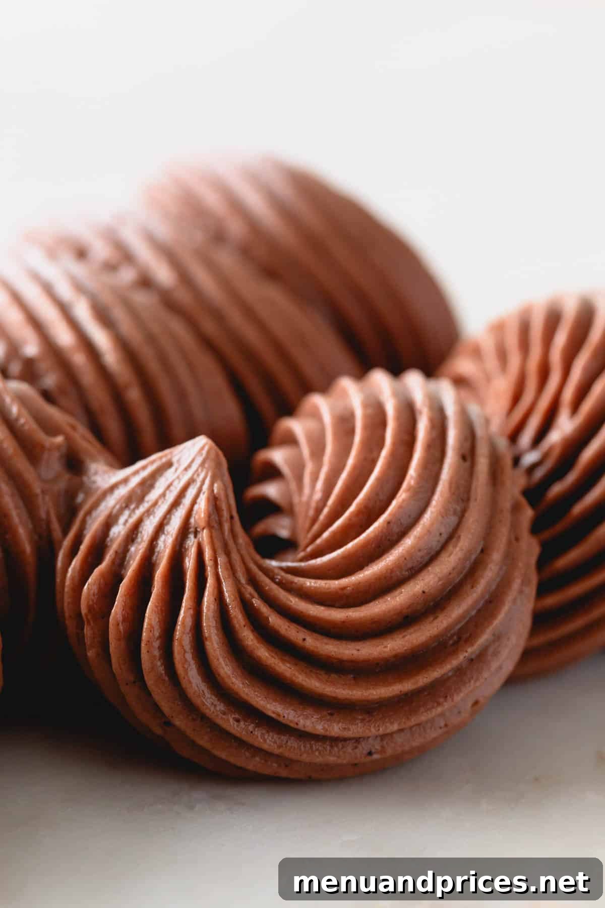 Luxe Chocolate Russian Buttercream 3 Close-up of elegantly piped chocolate Russian buttercream on a dessert, highlighting its smooth, glossy finish.