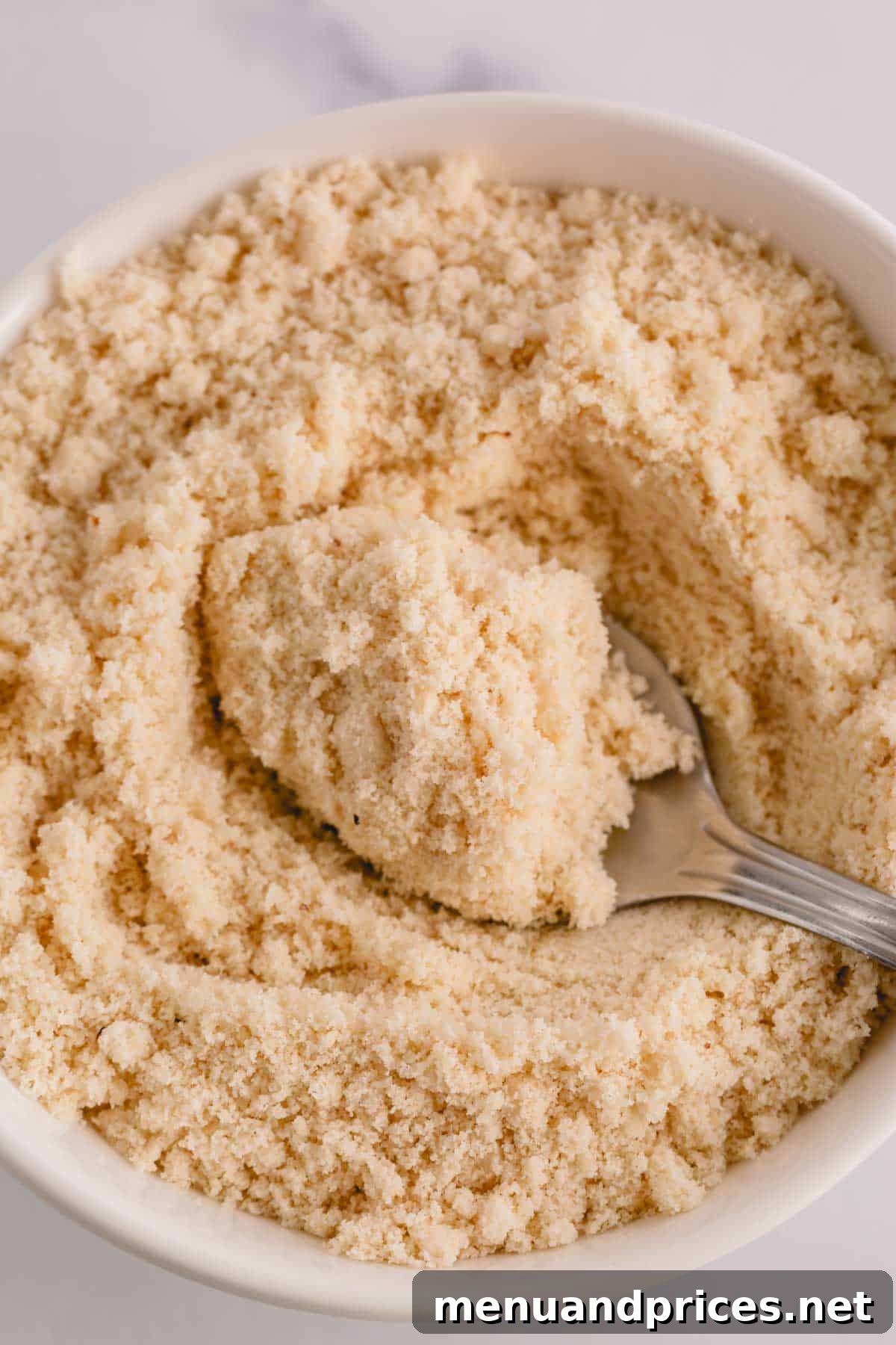 Mastering Dry Almond Flour: From Oily to Optimal 3 A pristine white bowl filled with high-quality, light beige almond flour, ready for baking.