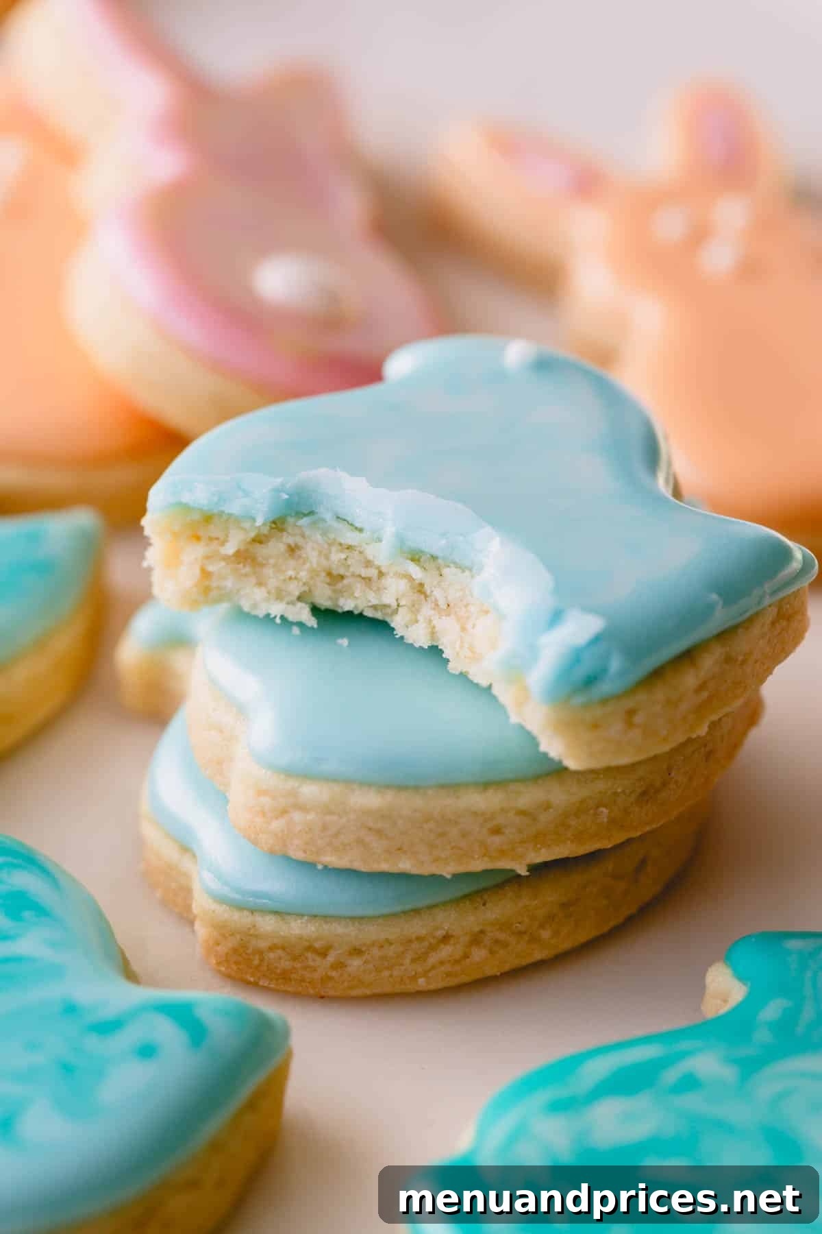 A delicious close-up of frosted Peeps Easter sugar cookies, with one cookie showing a bite taken out, highlighting the soft interior.