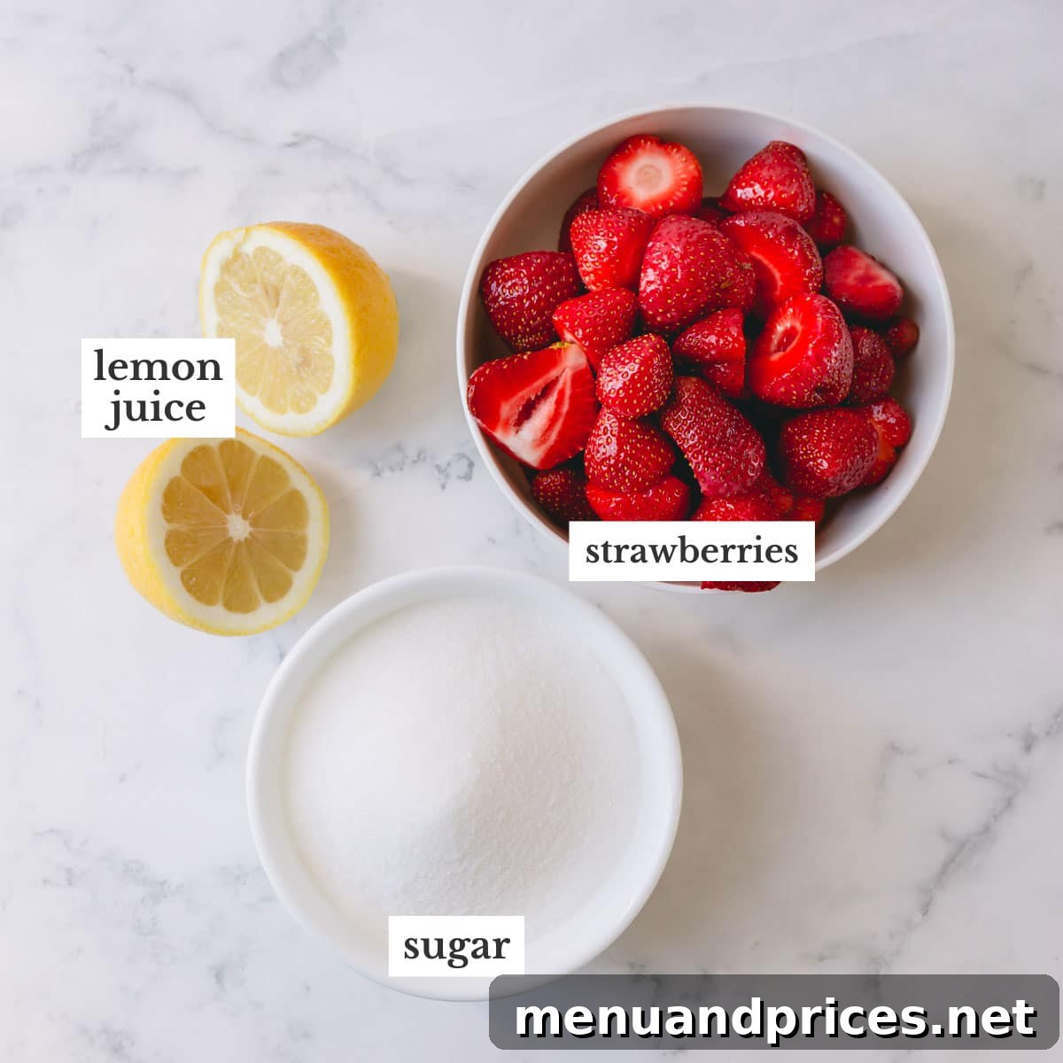 All the simple ingredients for homemade strawberry jam laid out: fresh strawberries, granulated sugar, and bright lemons.