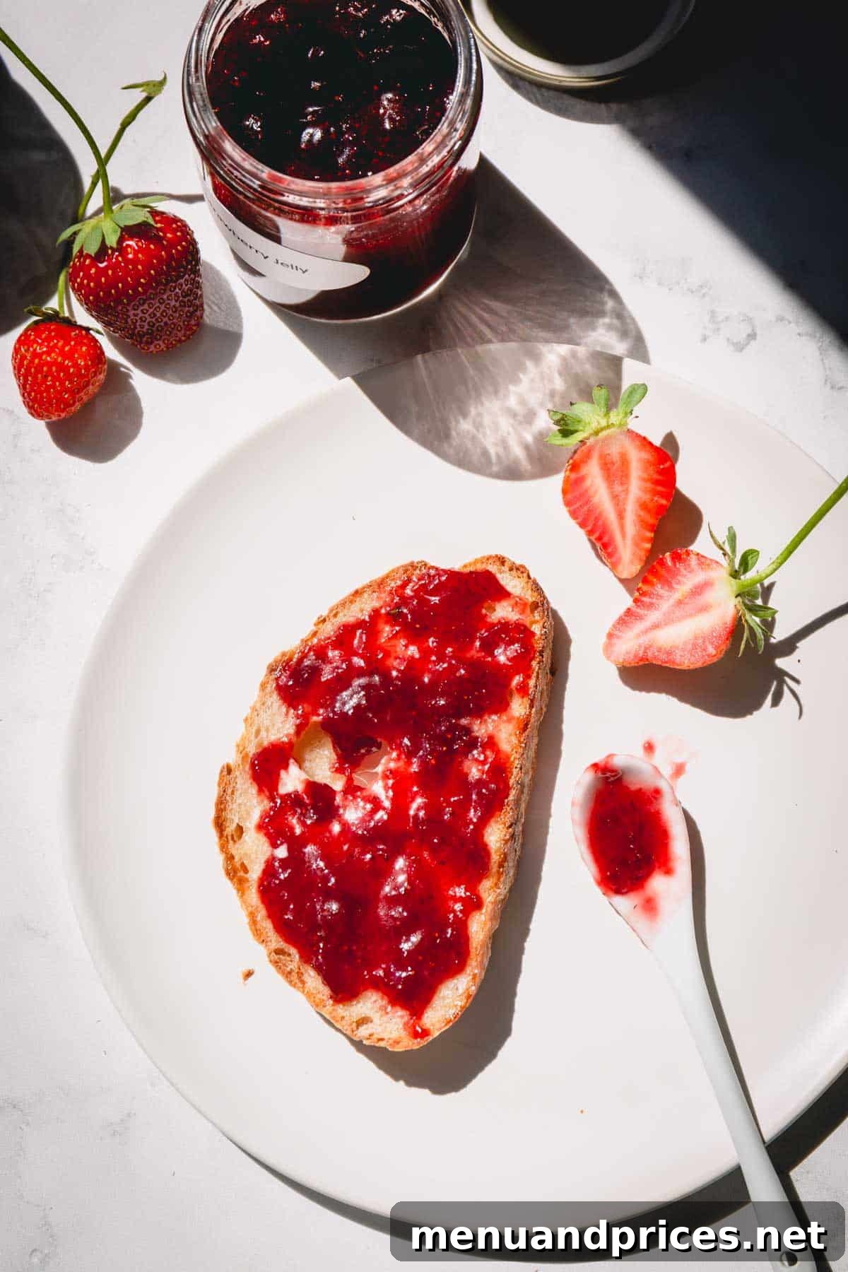 A delectable smear of homemade strawberry jam on a slice of fresh bread, showcasing its perfect spreadable texture.