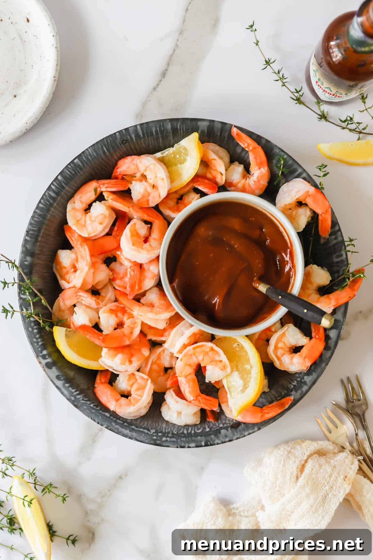 Zesty Prawn Cocktail 2 A beautifully arranged bowl of classic shrimp cocktail with a vibrant red cocktail sauce in the center, garnished with fresh lemon wedges.