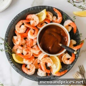 A bowl of succulent cocktail shrimp with homemade cocktail sauce in the center, ready to be enjoyed.