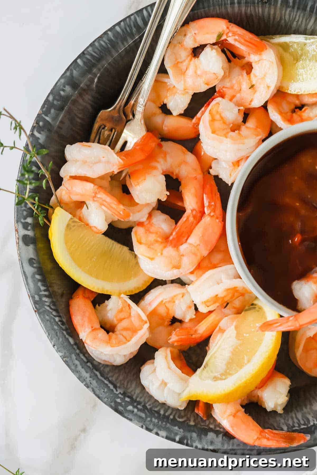Zesty Prawn Cocktail 3 A bowl of cocktail shrimp served with lemon wedges and a small bowl of cocktail sauce, showcasing the vibrant colors and appealing presentation.