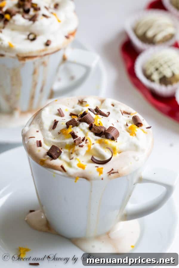 Rich orange hot chocolate with whipped cream, made with whole milk and high quality chocolate, ready to be enjoyed as a winter comfort drink.