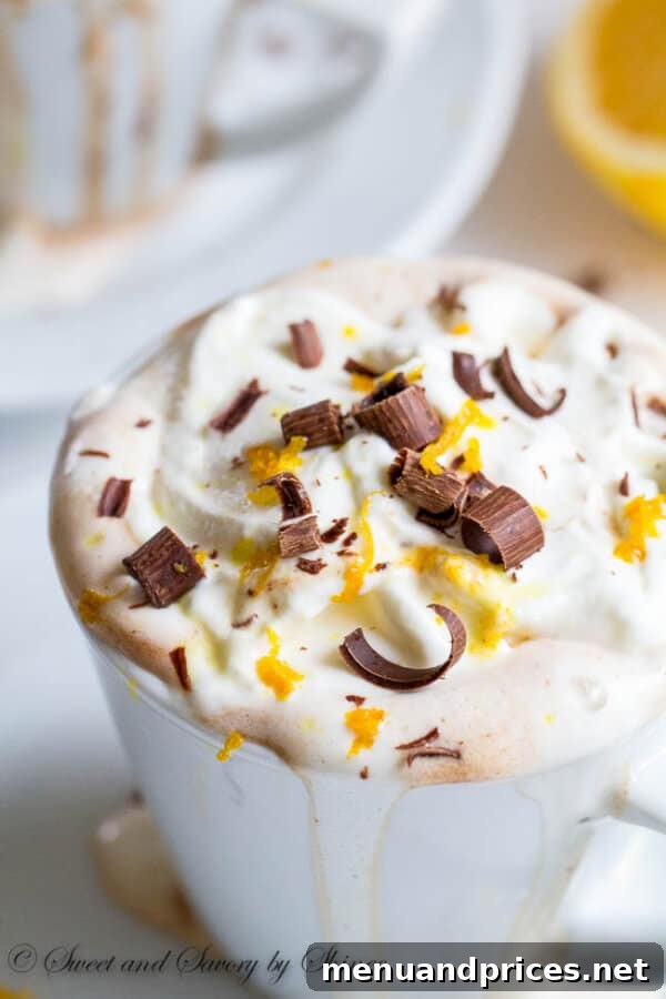 Ingredients for orange hot chocolate: whole milk, chocolate bars, and an orange, highlighting the quality of the components for a superior winter drink.