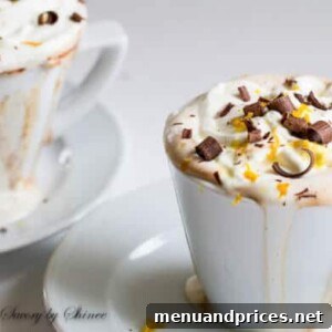 Orange Hot Chocolate, garnished with whipped cream and orange zest, presented in a mug for a cozy winter treat.