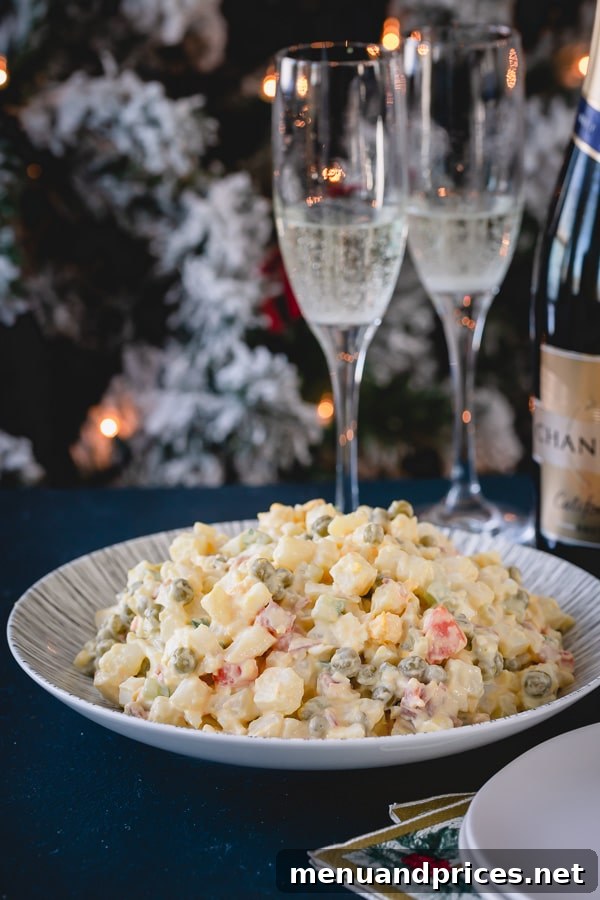 Timeless Russian Olivier 4 Olivier salad on a serving plate, beautifully garnished, with a festive Christmas tree and champagne glasses blurred in the background, signaling a celebration.