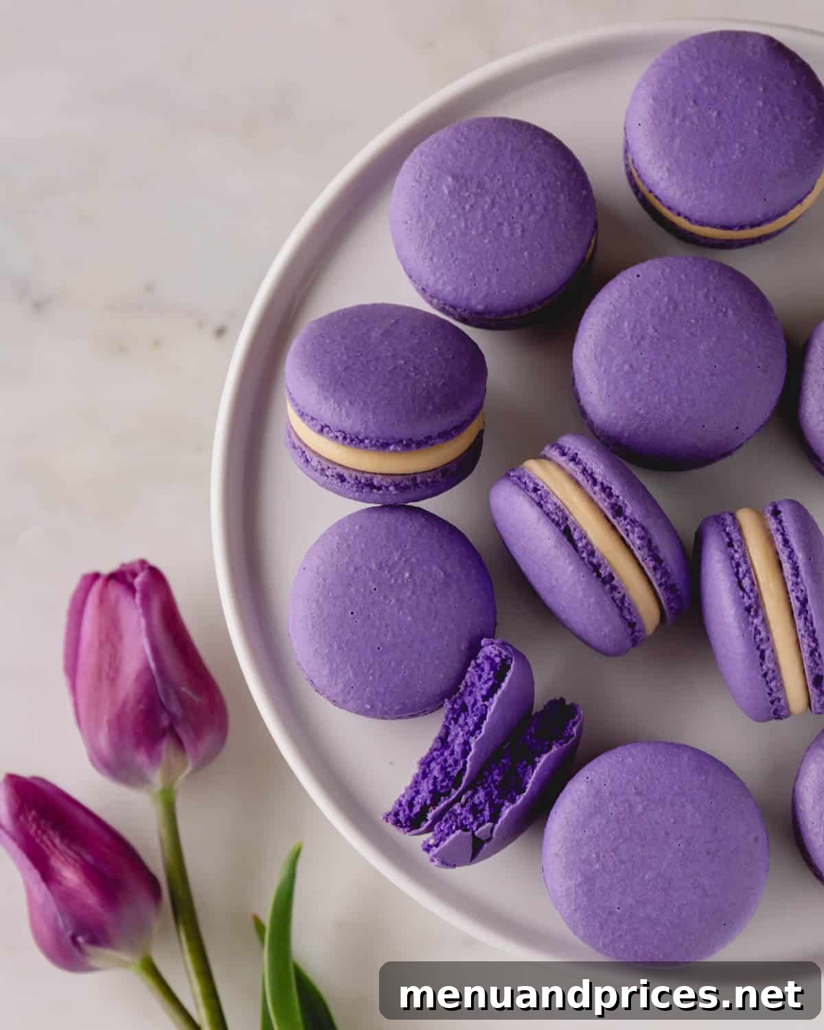 Elegant purple macarons with delicate feet, arranged artfully on a pristine white round dish, showcasing the vibrant and consistent color achievable with quality food coloring.