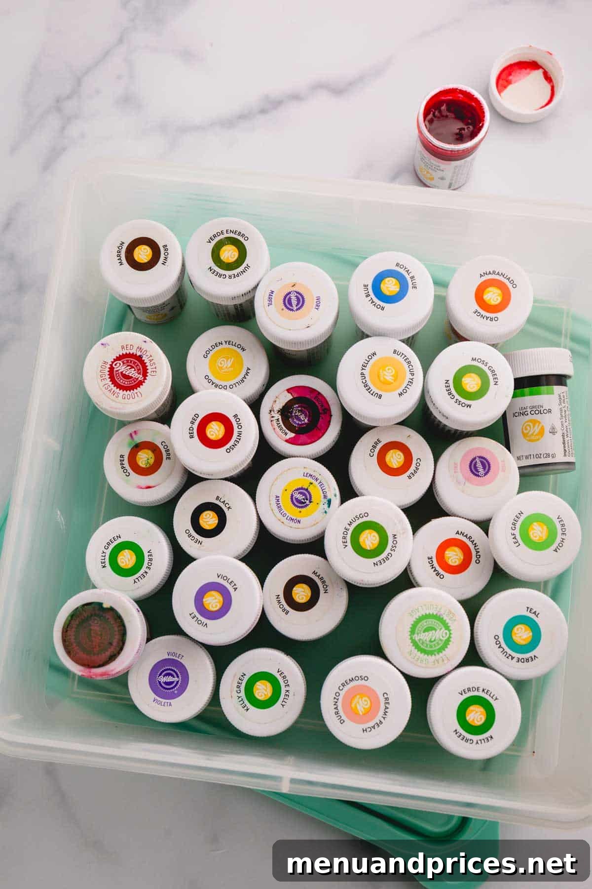 A collection of Wilton brand gel food colorings neatly organized in a clear plastic container, ready for a baking enthusiast to select the perfect shade.