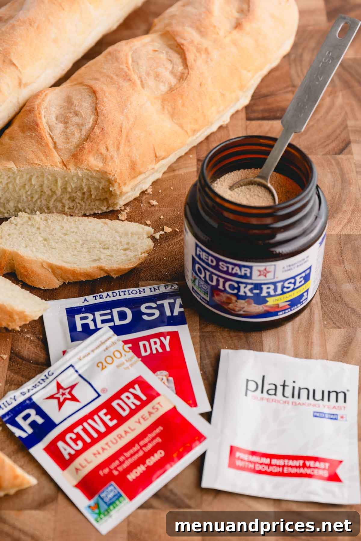 Yeast Essentials: Types and Their Ideal Uses 3 A rustic wooden cutting board showcasing packets of various Red Star Yeast brand yeasts, a jar of quick rise yeast, and elegantly sliced French bread, emphasizing the versatility of yeast in baking.