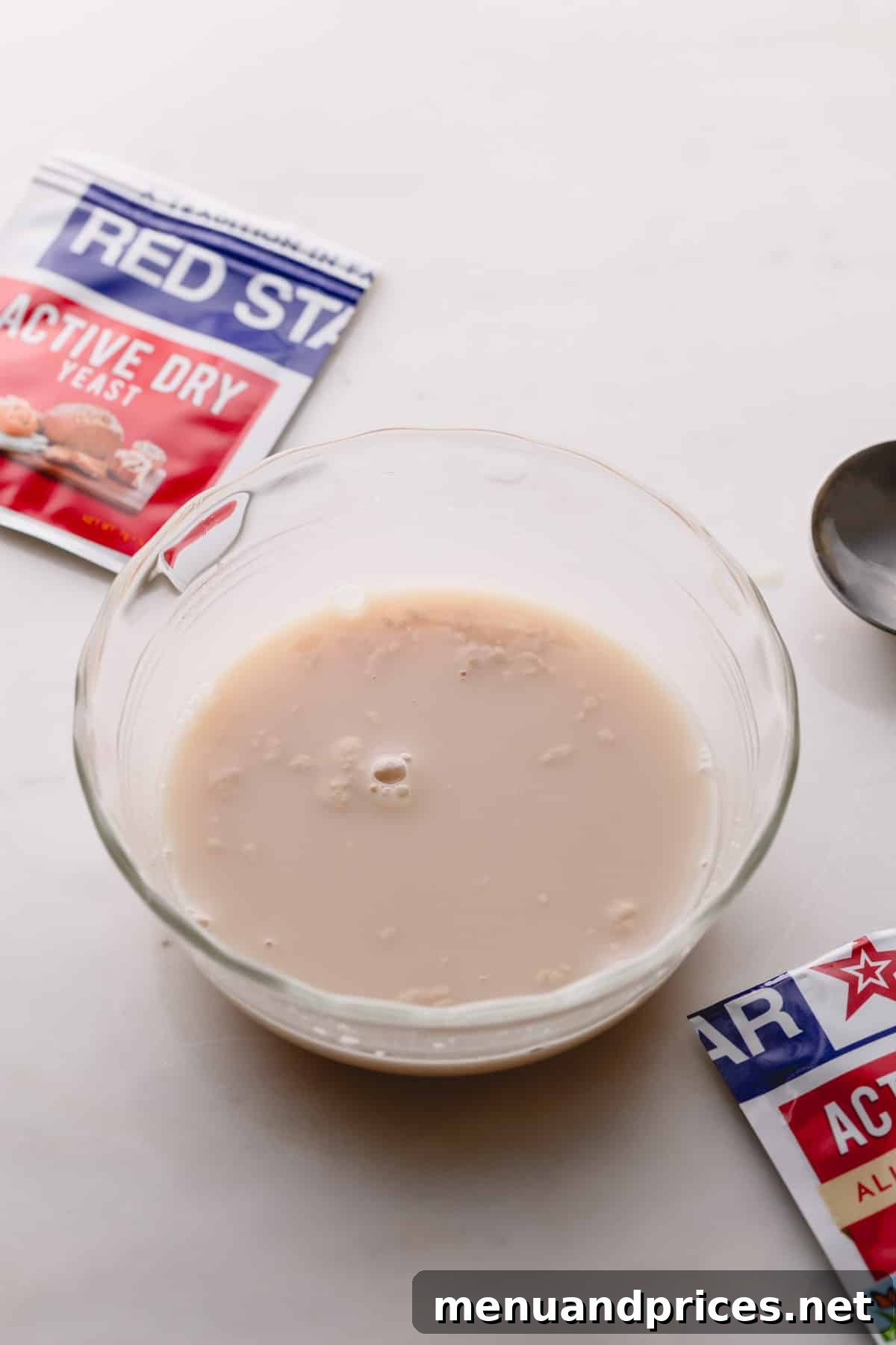 Yeast Essentials: Types and Their Ideal Uses 7 A small glass bowl holding a freshly mixed concoction of yeast, warm water, and sugar, just moments after combination.
