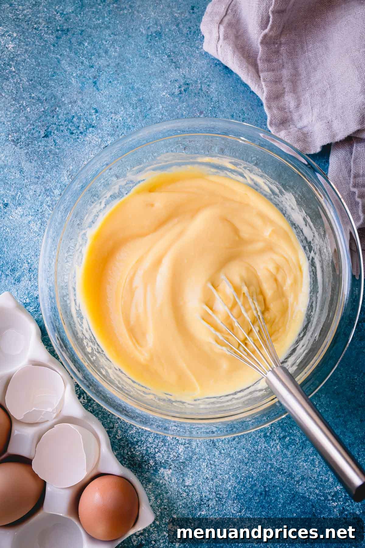 Mastering Thickening Agents 3 Smooth pastry cream in a glass bowl with a whisk, demonstrating a perfectly thickened texture.