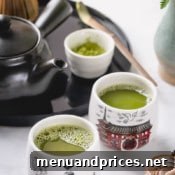 A close up of a bowl of matcha tea with a whisk.