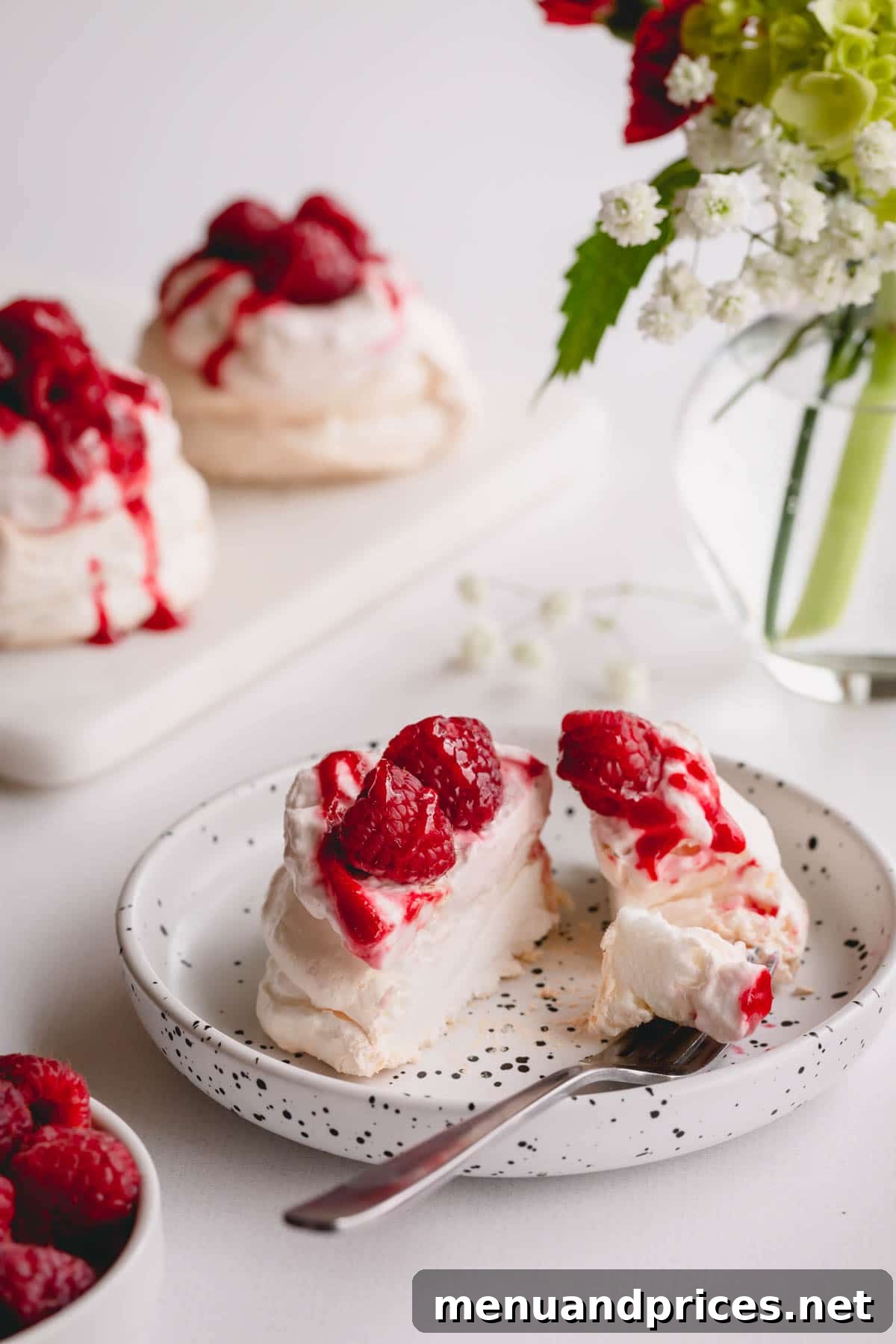 Petite Raspberry Pavlova Clouds 5 Mini pavlova, topped with raspberry whipped cream, raspberry sauce and fresh raspberries, sliced in half.
