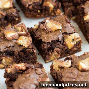 Close-up of a single Snickers brownie square with a bite taken out, revealing the soft, fudgy interior and chewy Snickers pieces.