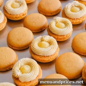 Lemon macaron shells with a ring of buttercream and lemon curd in the center.