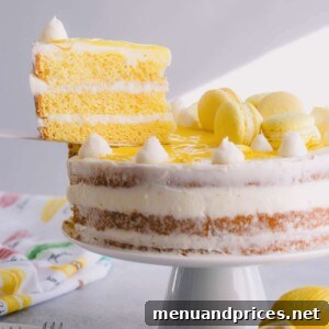 Lemon layer cake on a cake stand with one slice lifted.