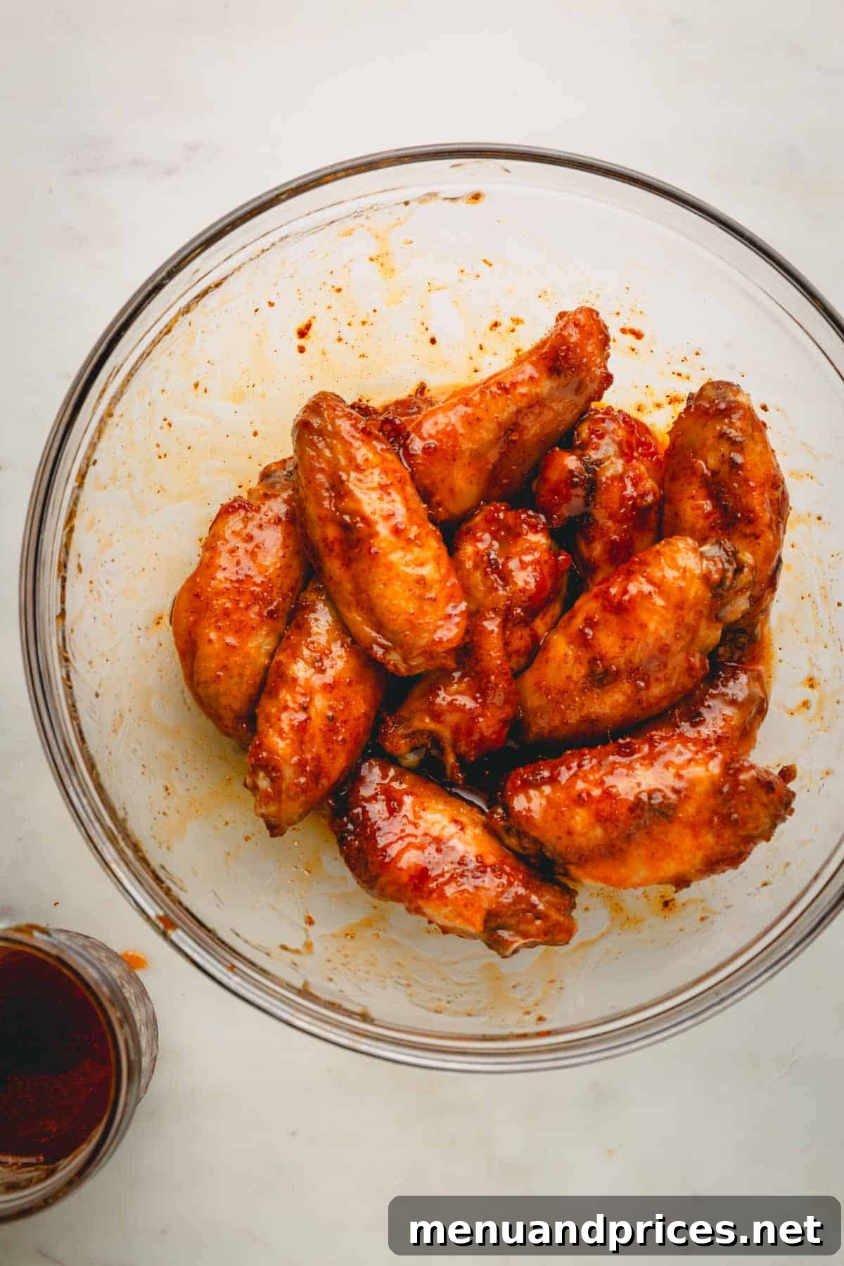 Sticky Sweet Heat Wings 12 A bowl of hot honey chicken wings, perfectly coated in the sweet and spicy sauce, ready to be devoured.