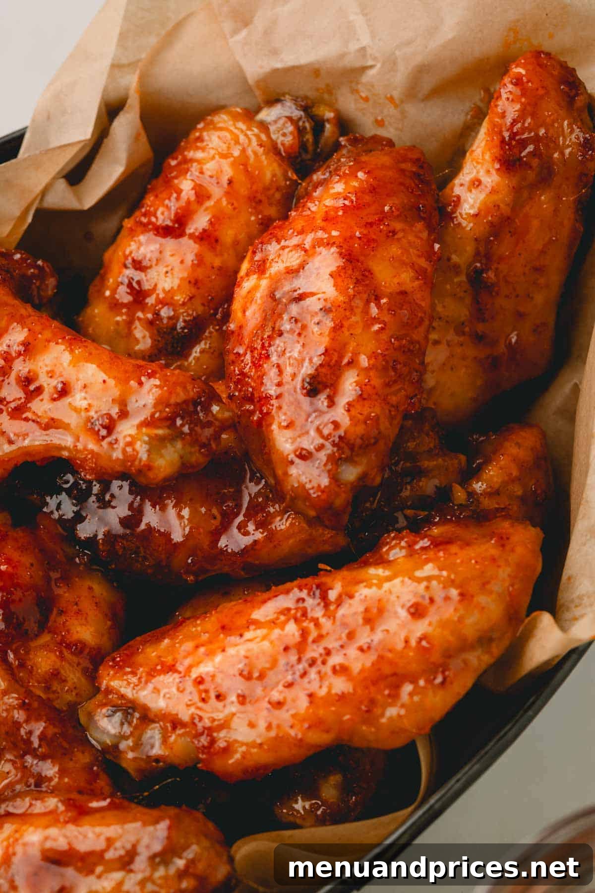 Sticky Sweet Heat Wings 3 A second view of a basket overflowing with golden-brown hot honey chicken wings.