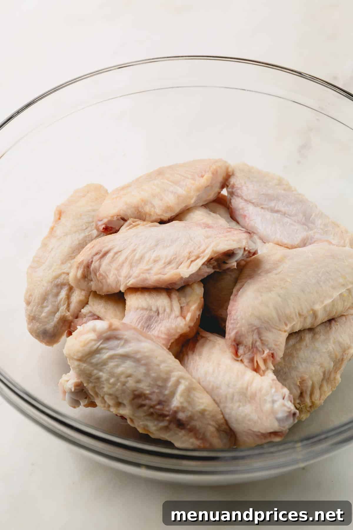 Sticky Sweet Heat Wings 6 Raw chicken wings meticulously arranged in a bowl, ready for seasoning.