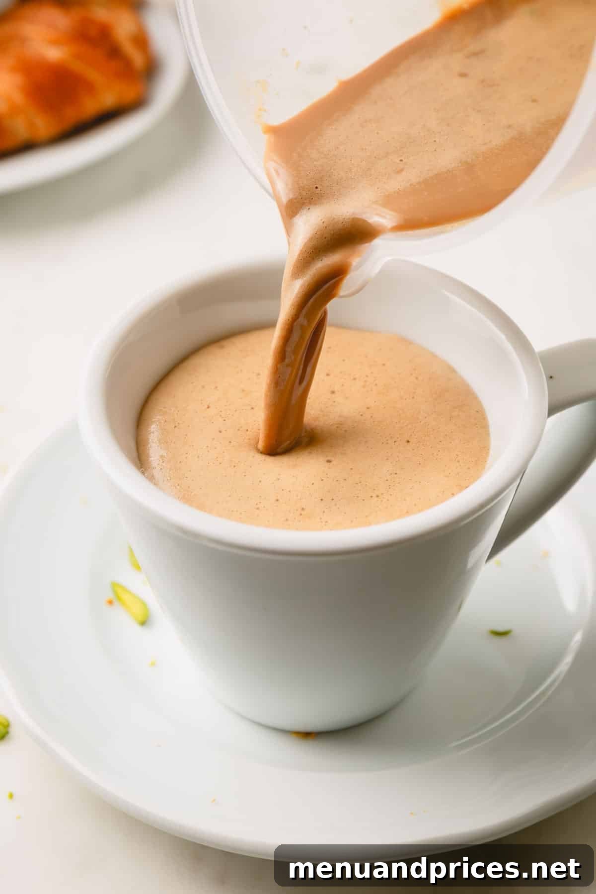 Pistachio latte being poured into a mug.