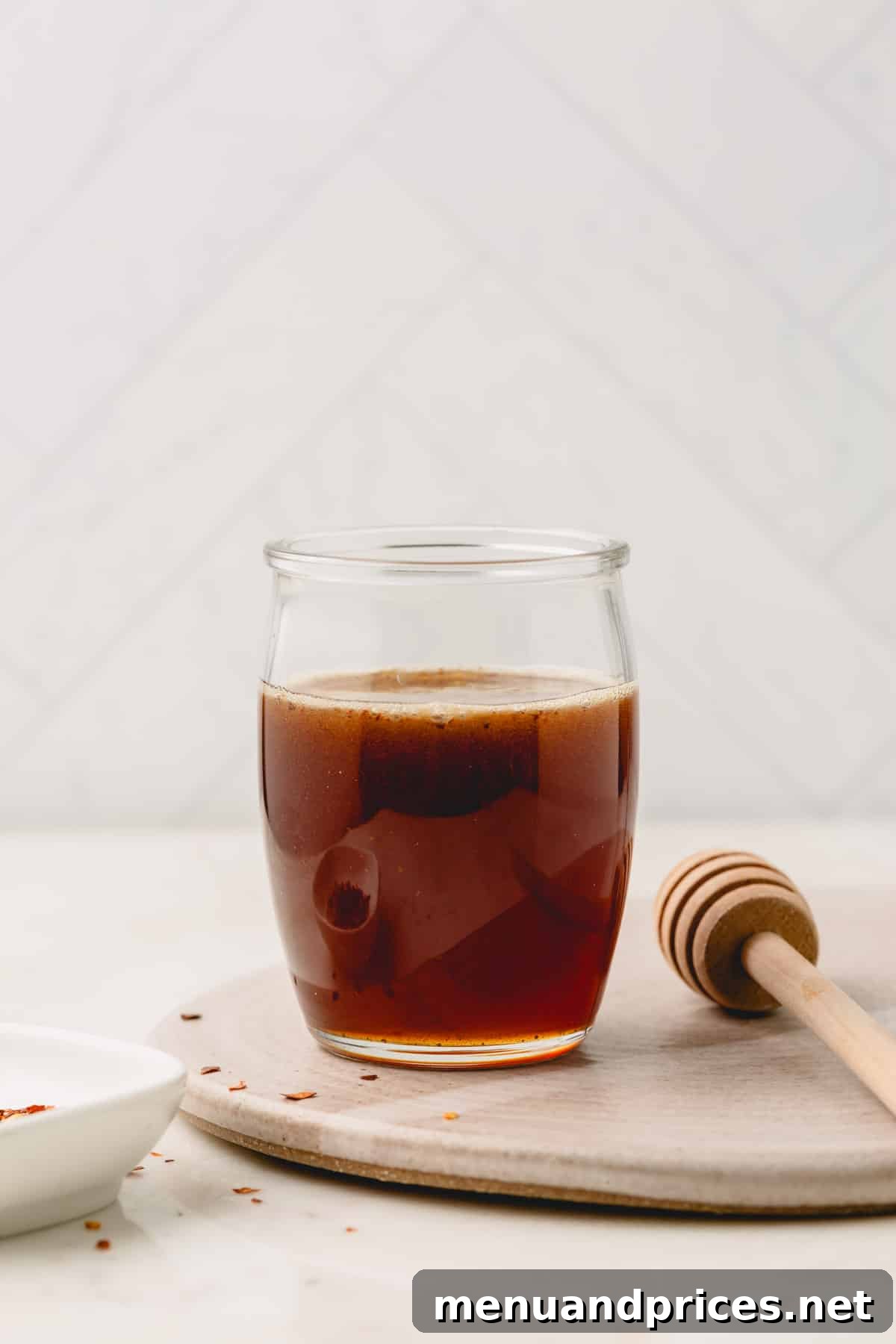 Sweet Heat Honey Formula 3 A beautifully presented jar of homemade hot honey, with a honeycomb dipper resting beside it, ready to be served.