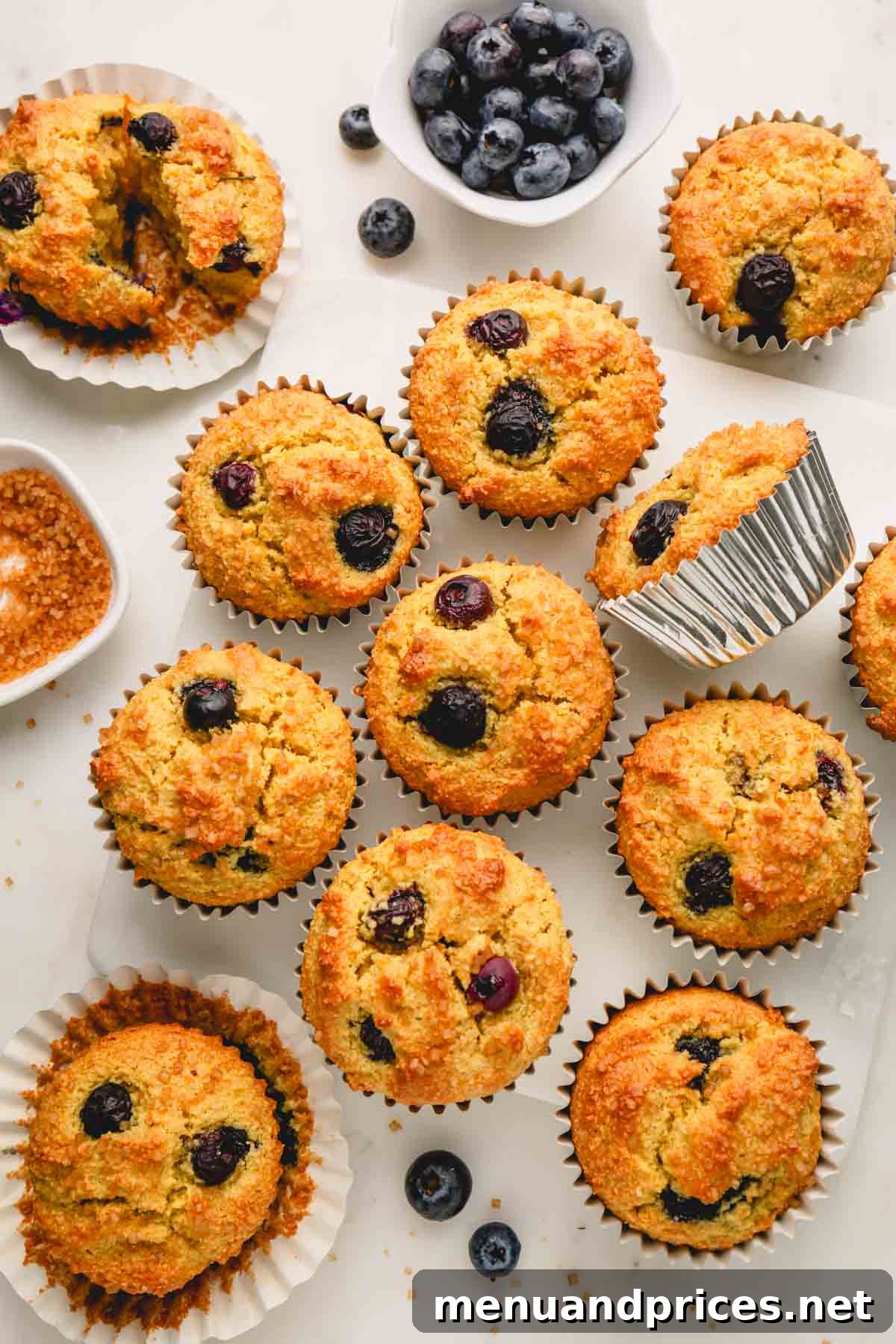 Moist Almond Flour Blueberry Muffins 13 A dozen freshly baked almond flour blueberry muffins, each nestled in its paper liner, arranged appealingly.