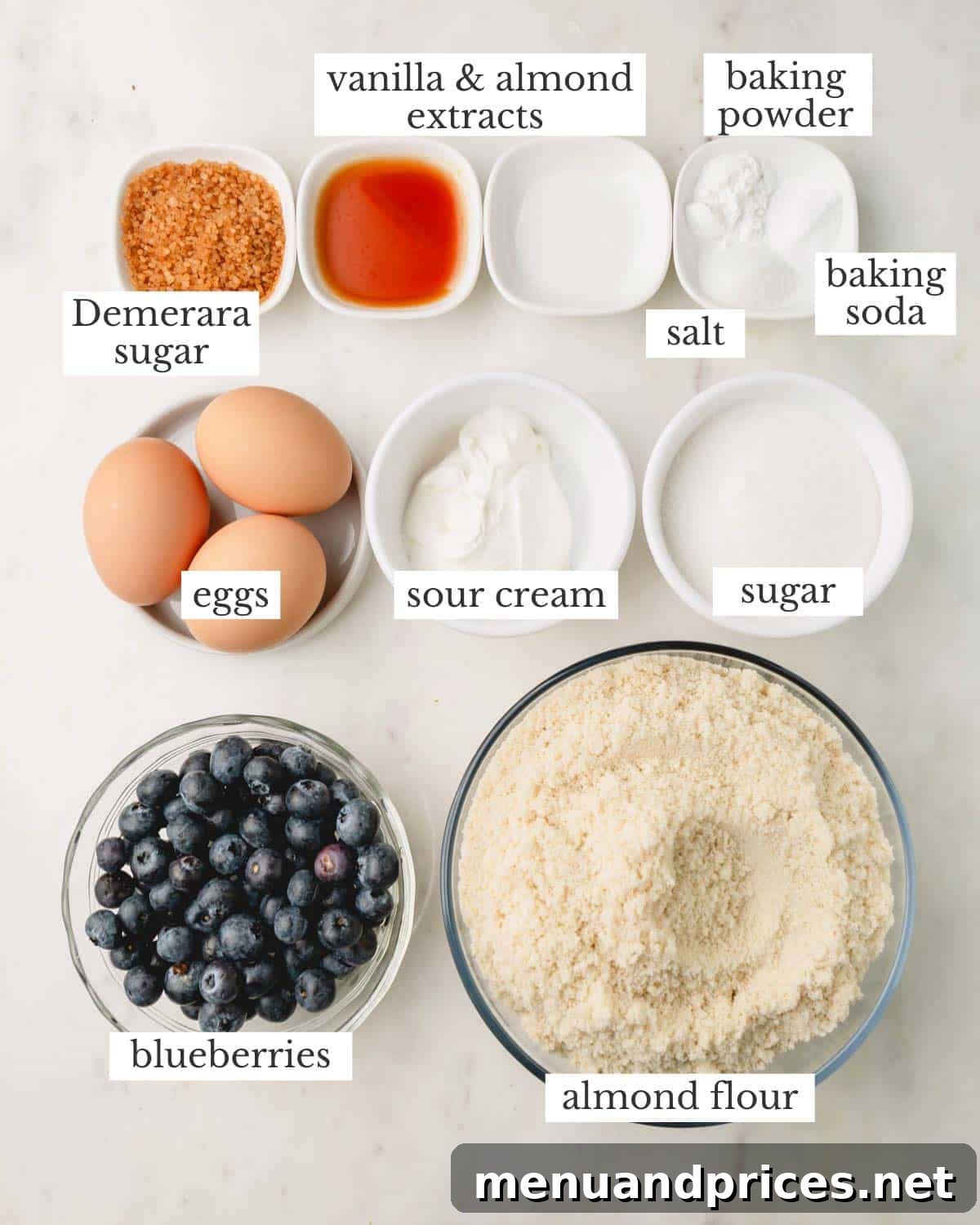 Moist Almond Flour Blueberry Muffins 4 A vibrant flat lay of ingredients, including almond flour, blueberries, eggs, and yogurt, ready to make delicious blueberry muffins.